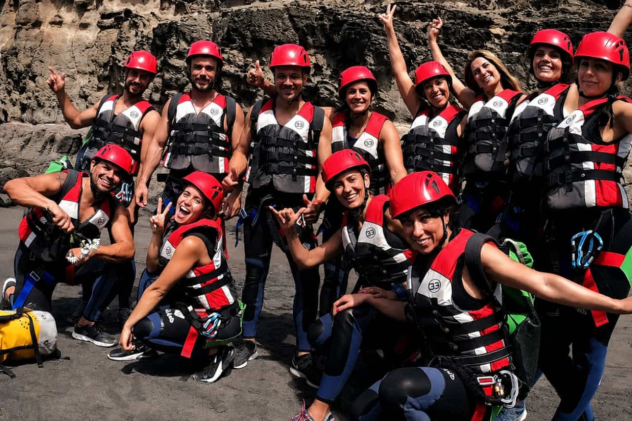 Group of friends laughing in a shallow sea cave during a coasteering tour in Gran Canaria