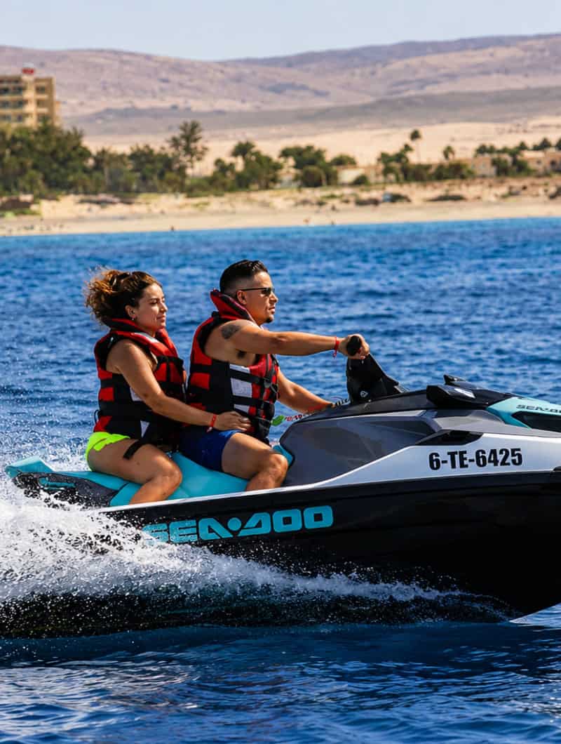 Couple sharing a Sea-Doo on a guided jet ski tour along the Corralejo coast.