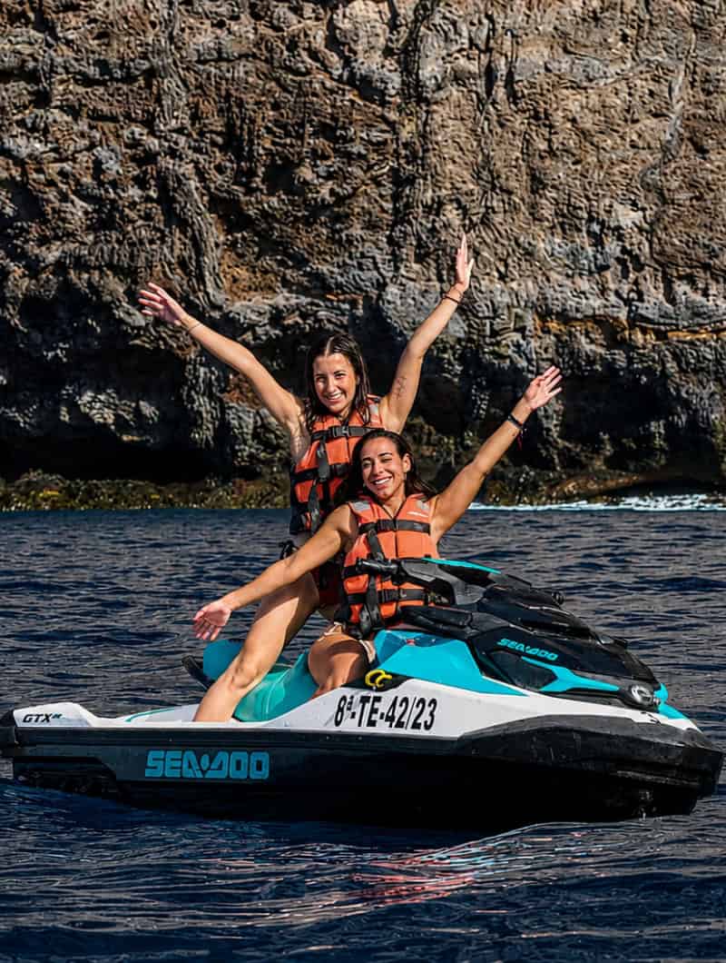 Two people having fun on a double jet ski during the jet ski safari Los Gigantes in Tenerife.