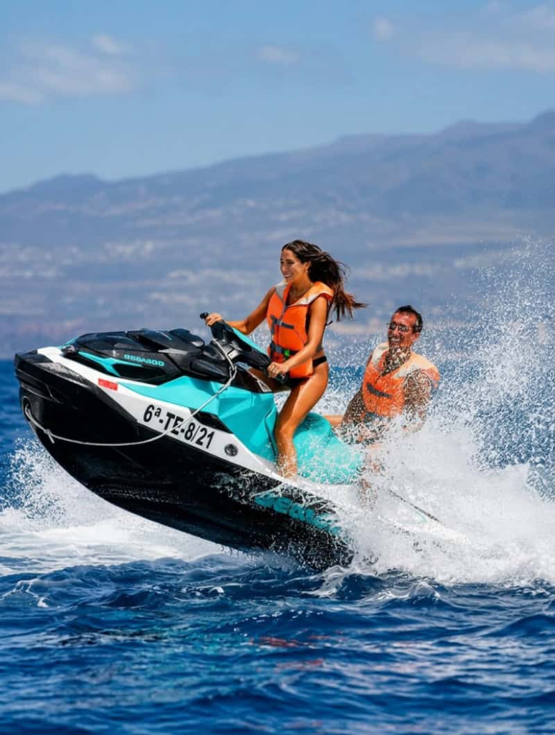 Two people sharing a Sea-Doo jet ski in Tenerife, showing the double jet ski option for two riders.