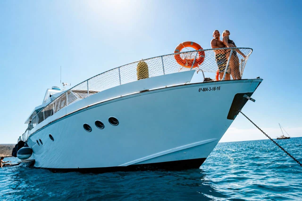 Family private boat trip Tenerife with parents relaxing while kids enjoy the water toys