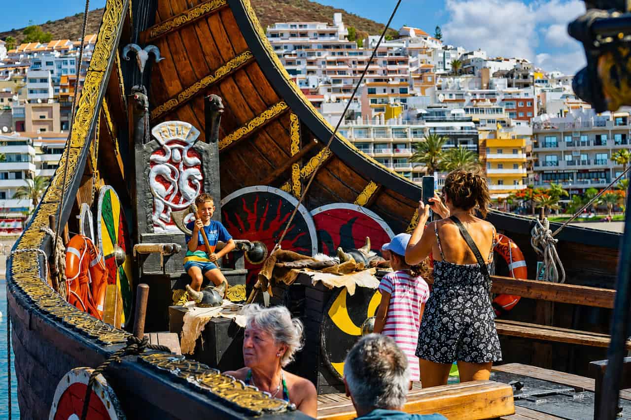 Child posing on the Viking throne onboard the Ragnarok Viking Boat in Tenerife during a family boat trip.