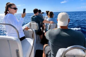 Guests on a dolphin watching boat trip from Morro Jable in Fuerteventura enjoying the open ocean while searching for dolphins.