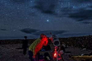 Guest looking through a telescope during a Fuerteventura stargazing tour under the night sky