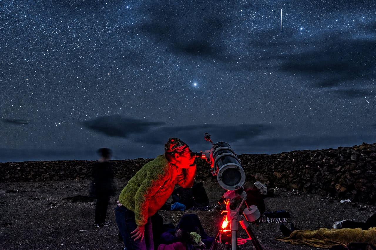 Guest looking through a telescope on a Fuerteventura stargazing tour