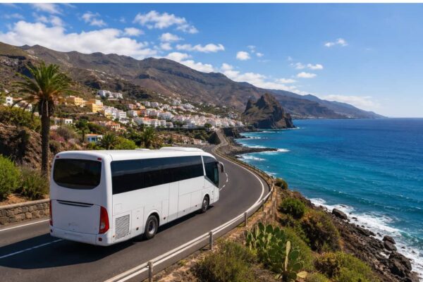 Tour coach driving along the scenic west coast of Gran Canaria with ocean views, mountain landscapes and traditional coastal villages during a full-day island tour.