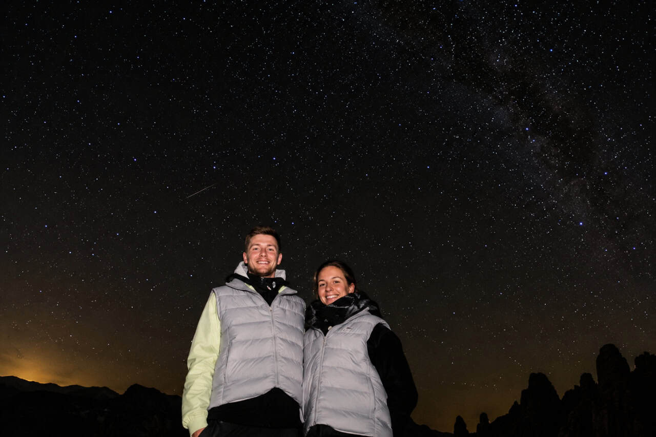 Couple standing beneath the Milky Way during a stargazing experience in Gran Canaria with a clear night sky full of stars.