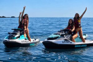 Four women enjoying a Corralejo jet ski tour on two Sea-Doo machines in Fuerteventura.