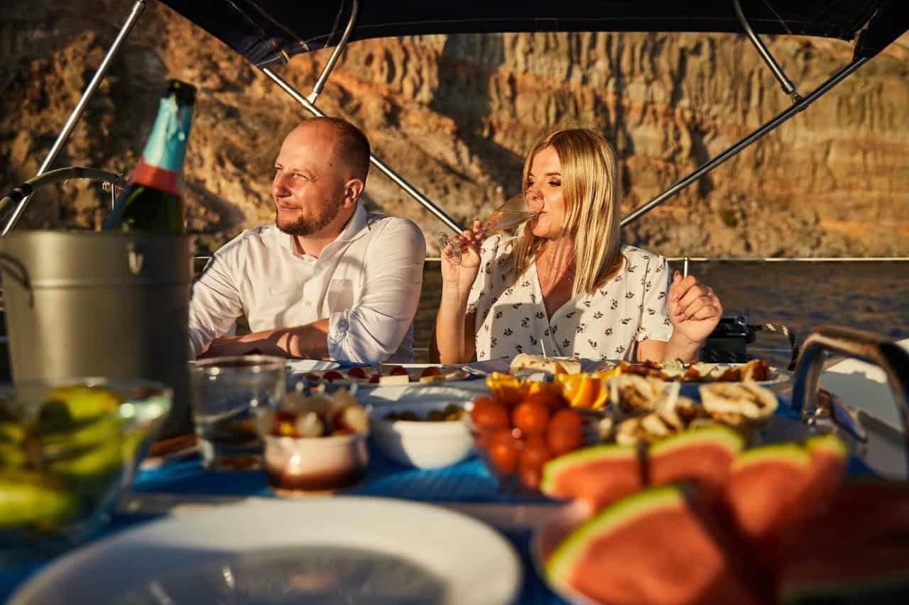 Guests enjoying food and drinks on the deck of the Karolka sailing yacht in Gran Canaria