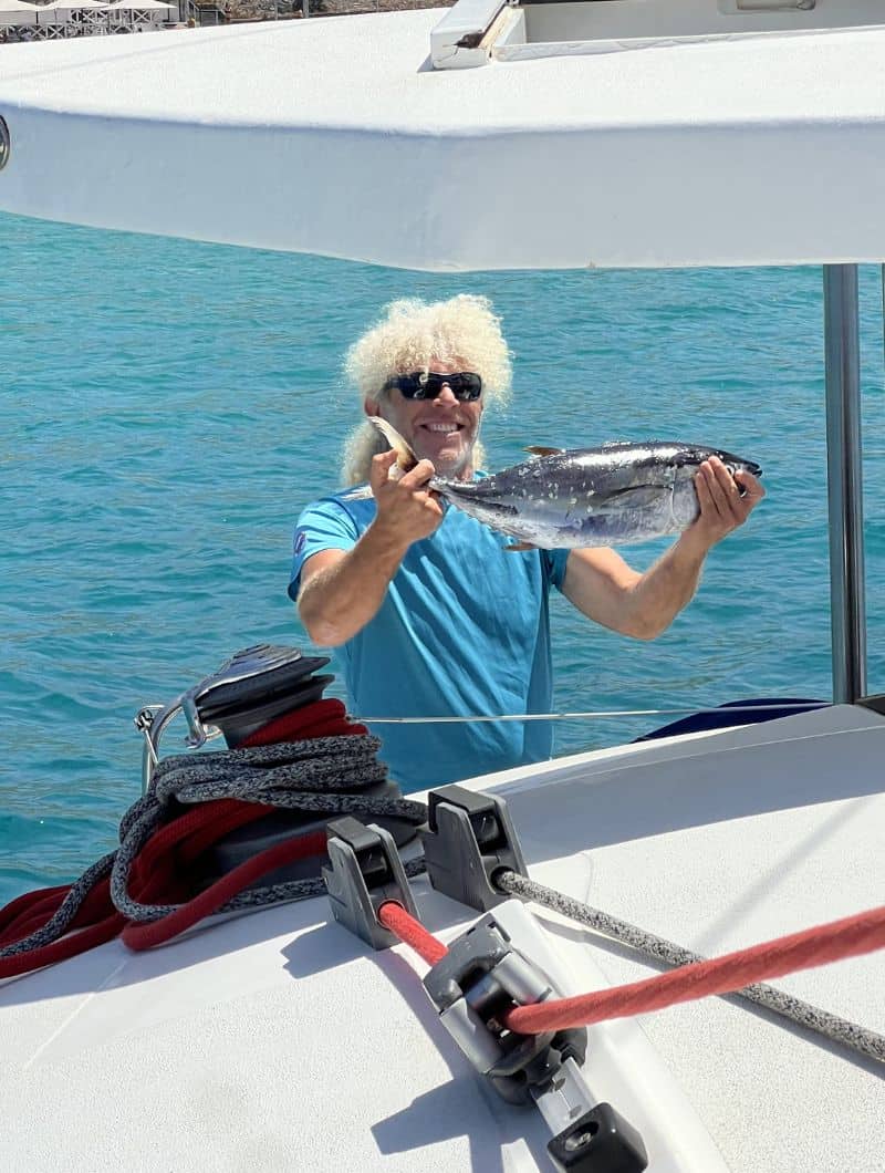 Paco holding freshly caught fish before the small group catamaran trip in Morro Jable, Fuerteventura