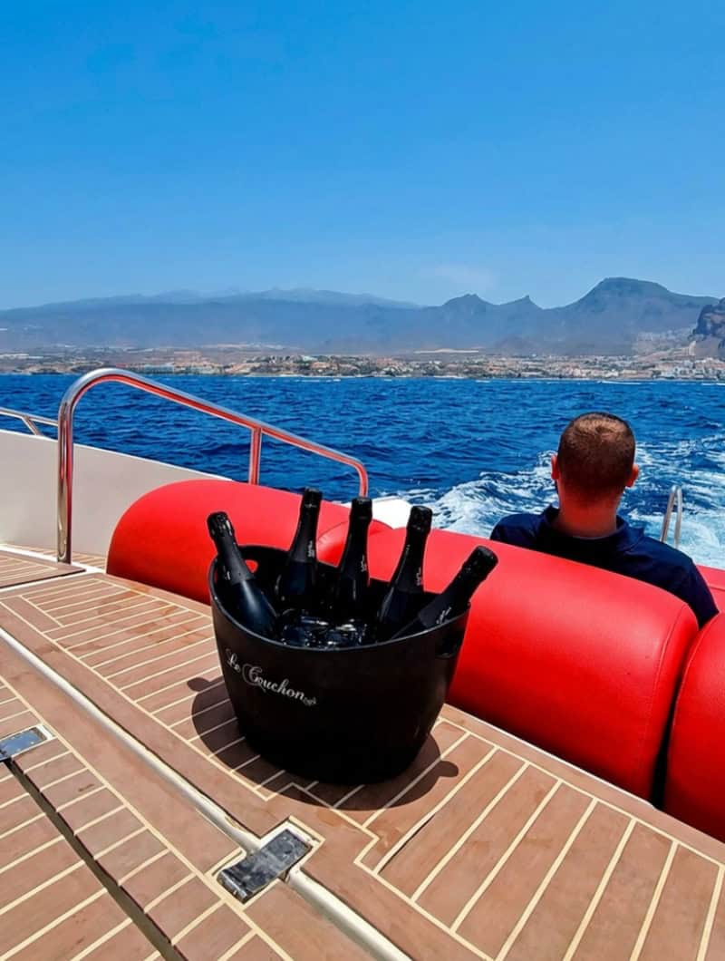 Crew member serving drinks to guests during a private Opera 60 boat charter in Tenerife