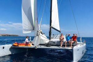 Guests relaxing on a private catamaran trip in Lanzarote with clear blue ocean views