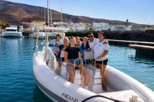 Guests boarding a private dolphin watching boat in Morro Jable Marina, Fuerteventura, before a private dolphin tour with free hotel pick-up.