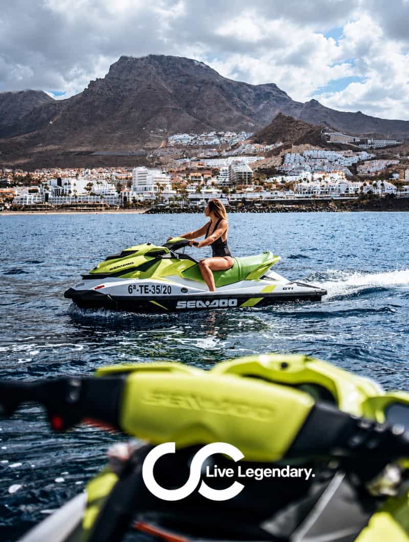 Rider on a premium Sea-Doo jet ski during a private jet ski trip in Tenerife with the coastline and mountains behind the calm open ocean.