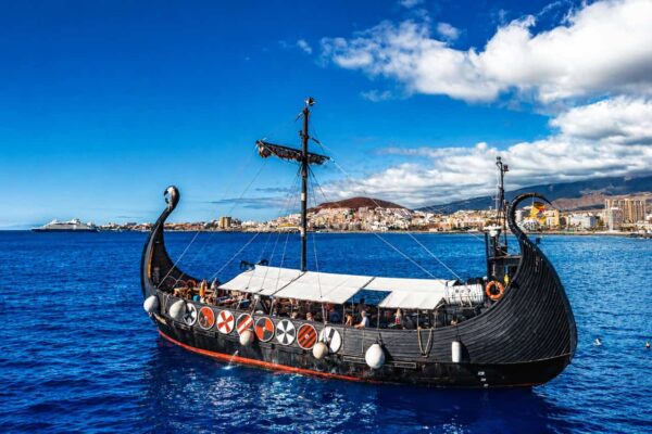 Ragnarok Vikingboot zeilt vanuit Los Cristianos op Tenerife met uitzicht op de oceaan en de zuidkust op de achtergrond.