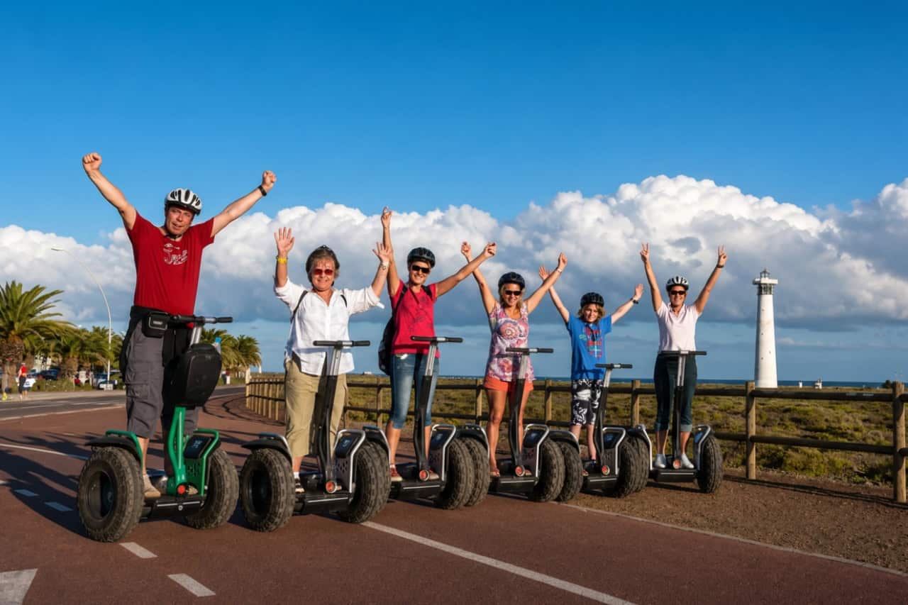 Group with arms raised on Segways near the Morro Jable lighthouse