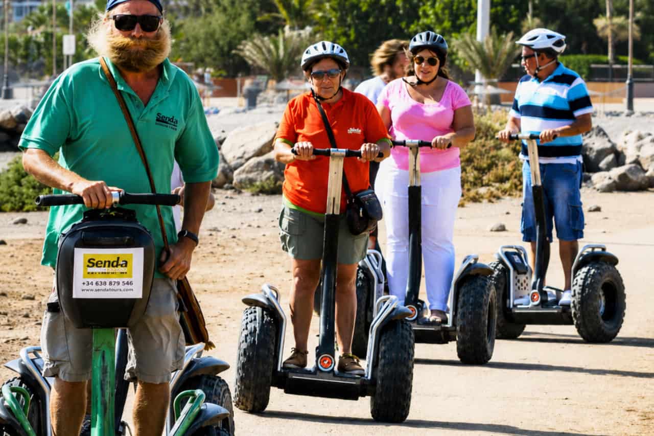 Instructor with a Segway group on a sandy coastal path