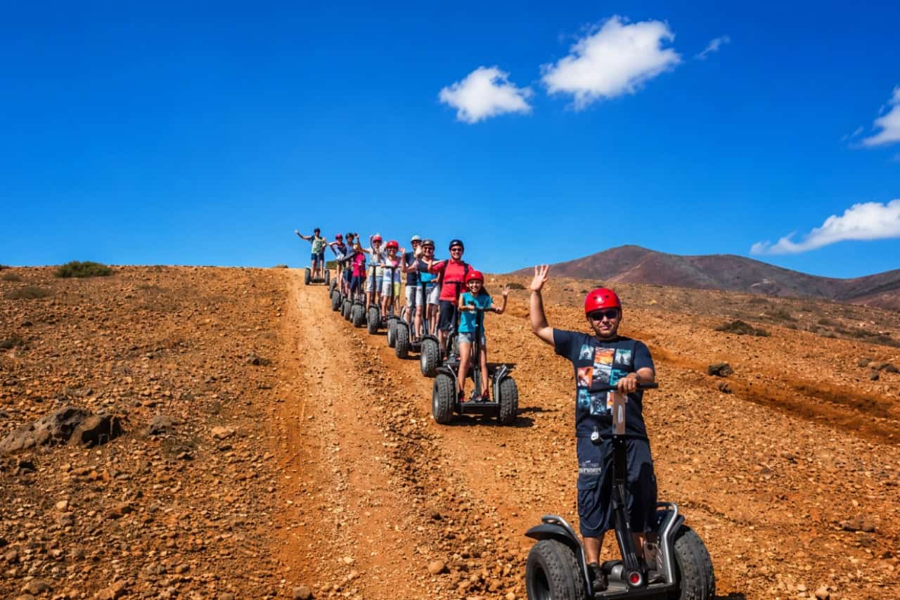 Guide leading Segway riders along a red dirt trail in Fuerteventura