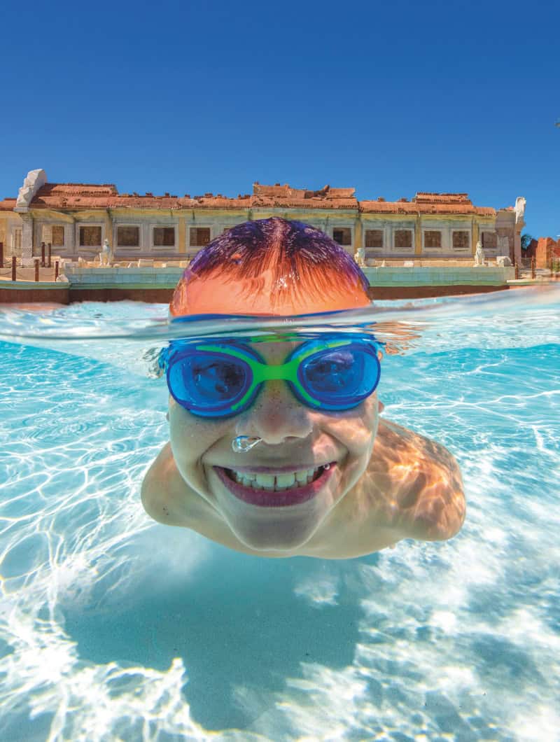 Child swimming with goggles in shallow water at Coco Beach Siam Park