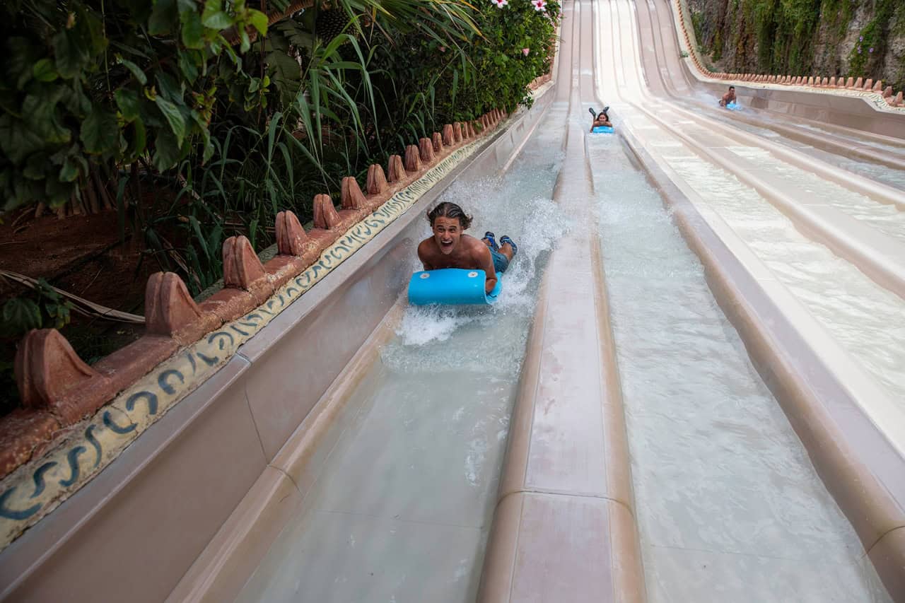 Rider racing head first down the Naga Racer mat slide at Siam Park, Tenerife