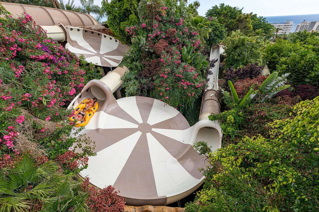Riders on the Singha water coaster winding through the greenery at Siam Park, Tenerife