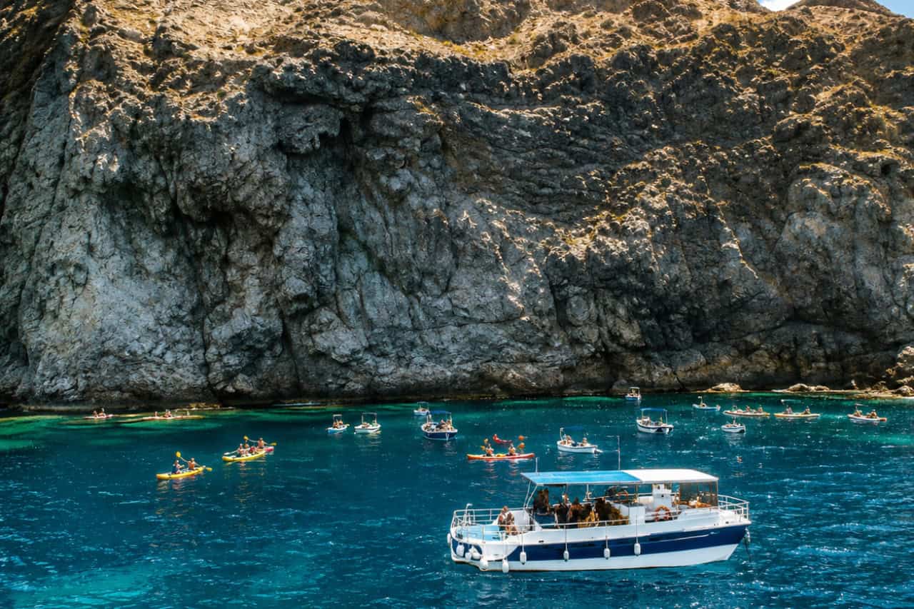 Snorkeling excursion boat anchored in a secluded bay surrounded by Tenerife's volcanic coastline.Snorkeling excursion boat anchored in a secluded bay surrounded by Tenerife's volcanic coastline.