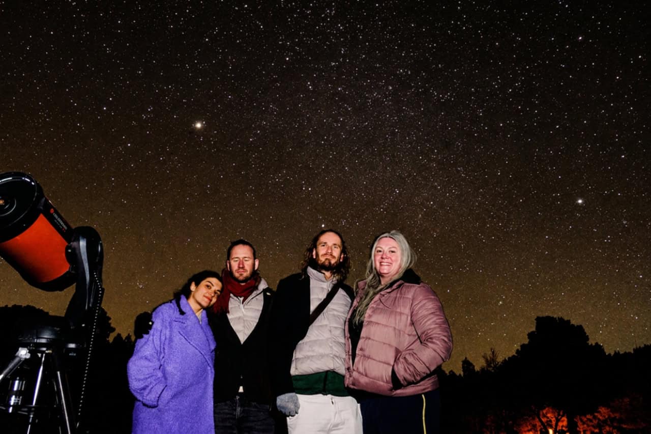 Small group enjoying a stargazing tour in Gran Canaria with telescope under the stars