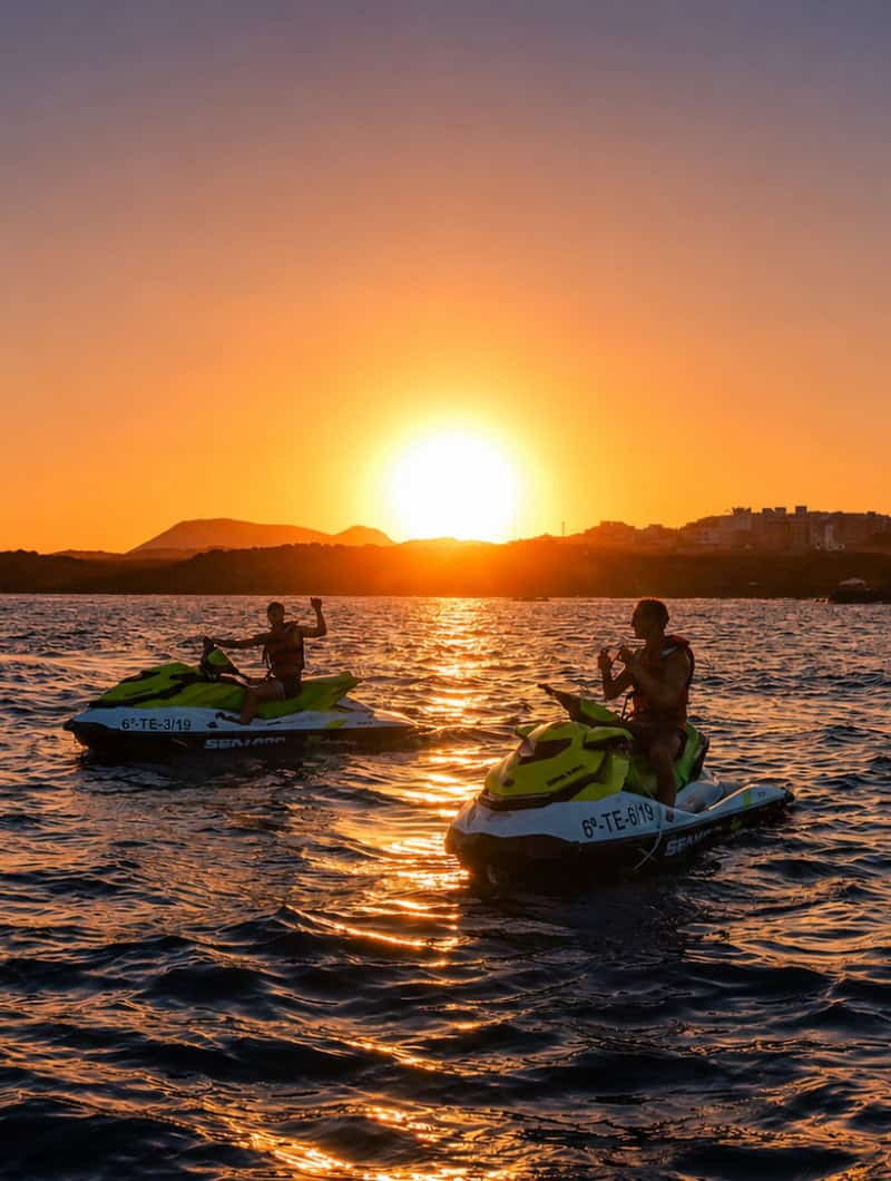 Jet skis floating on the ocean during a golden sunset jet ski safari in Tenerife.