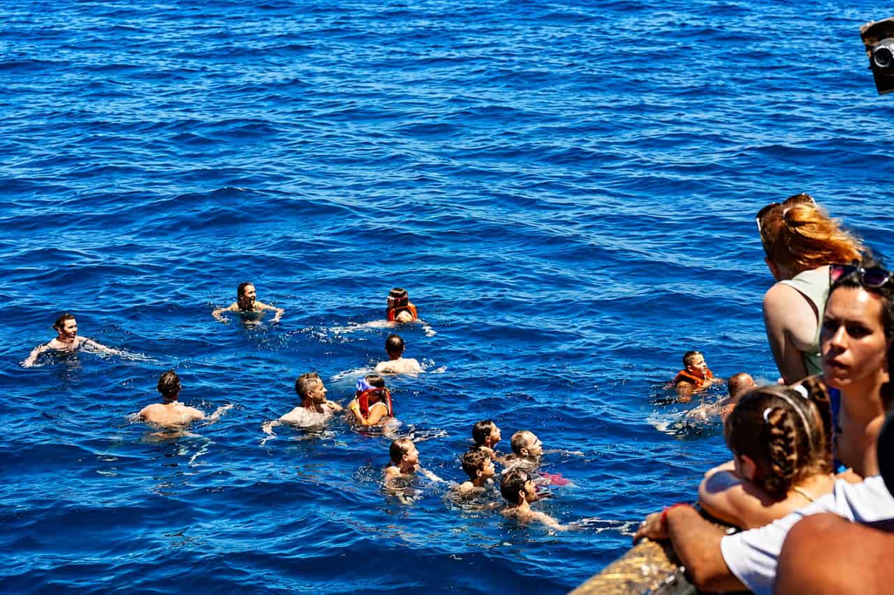 Guests swimming in the ocean during the Ragnarok Viking Boat trip in Tenerife.