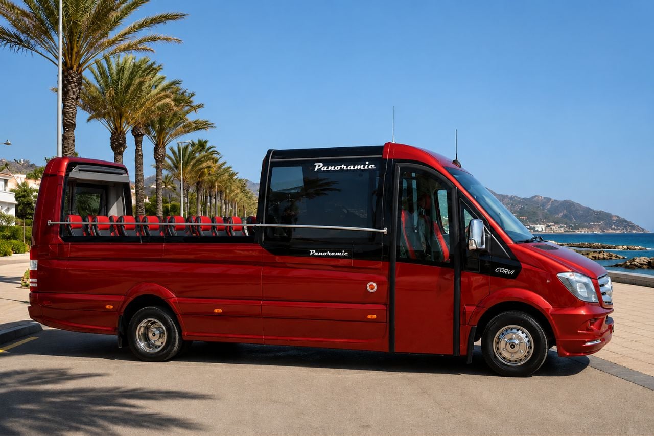 Red panoramic sightseeing bus parked along a palm-lined seafront promenade, ready for a guided coastal tour with open-air seating and scenic ocean views.