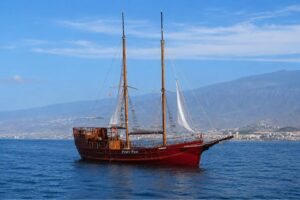 Traditional Portuguese gulet Peter Pan sailing off the coast of Los Cristianos, Tenerife during a whale watching boat trip with Mount Teide visible in the background.