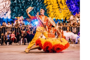 Traditional dancers performing in colourful costumes during a cultural folklore show in Gran Canaria with an audience watching.