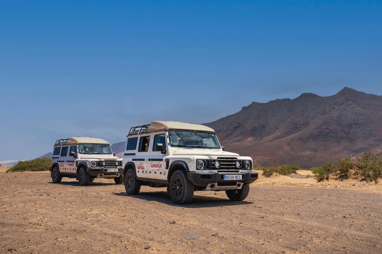 Two 4x4 Jeep Safari vehicles driving along the volcanic landscape and mountains of Fuerteventura.