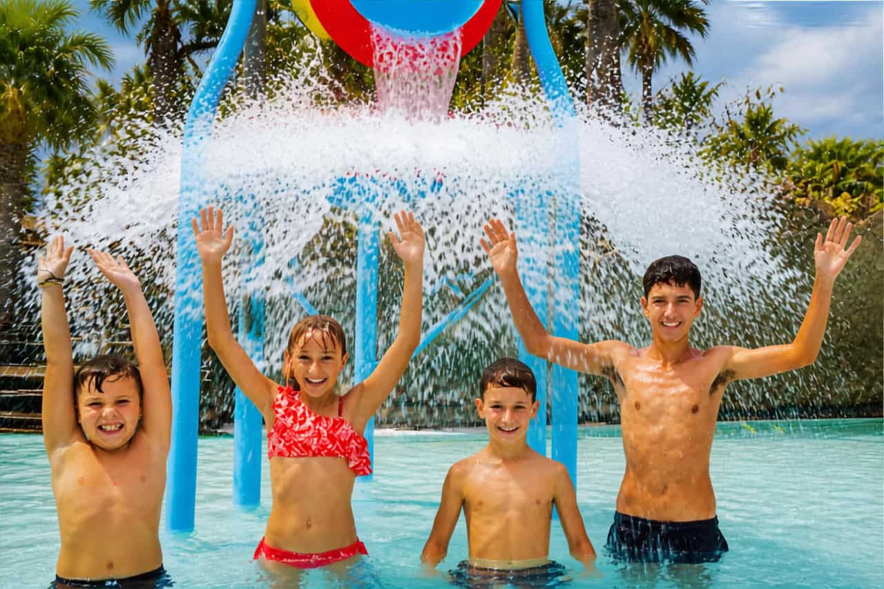 Children under the tipping water bucket at Aqualand