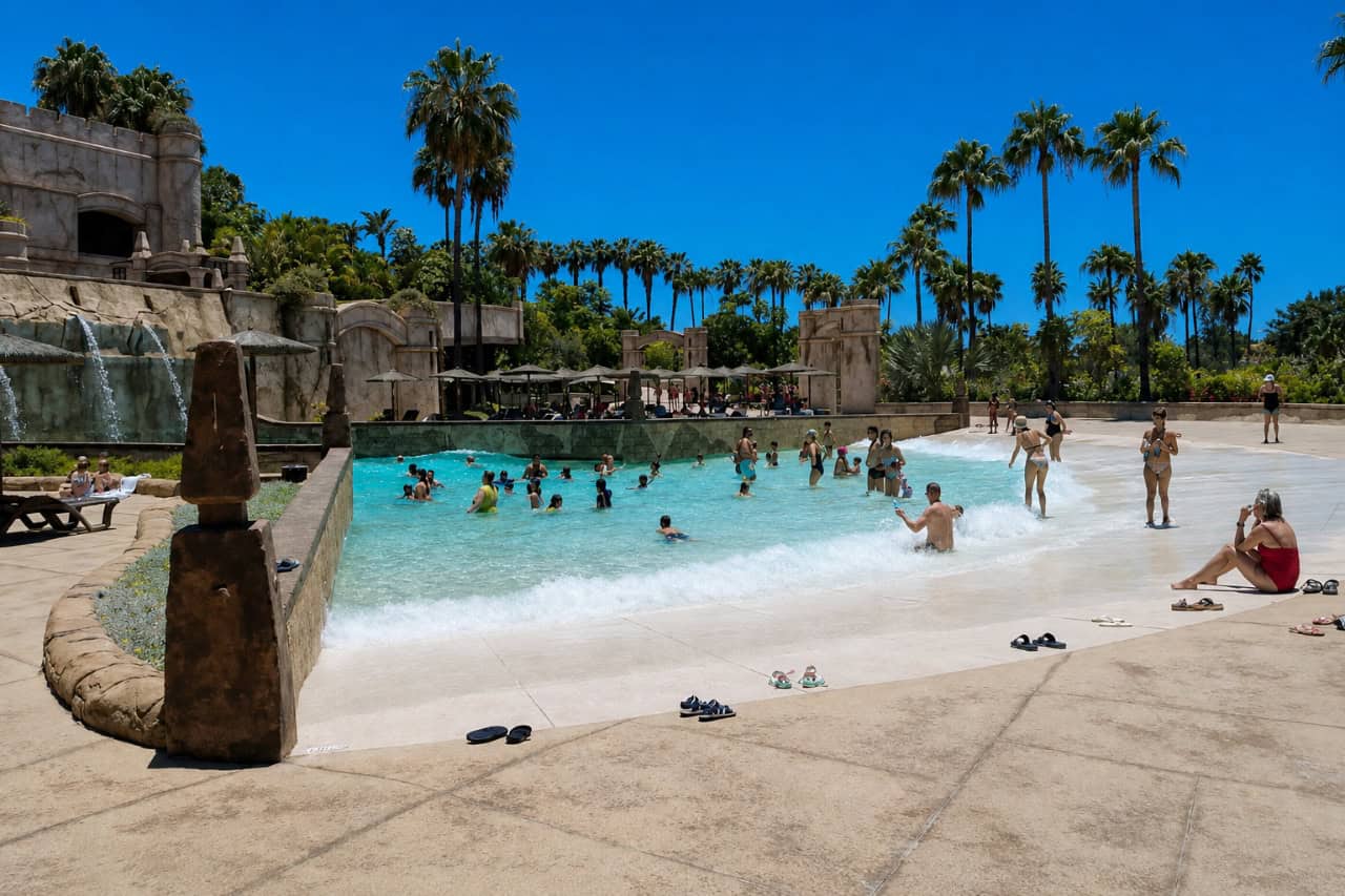 Families in the wave pool under the palms at Aqualand