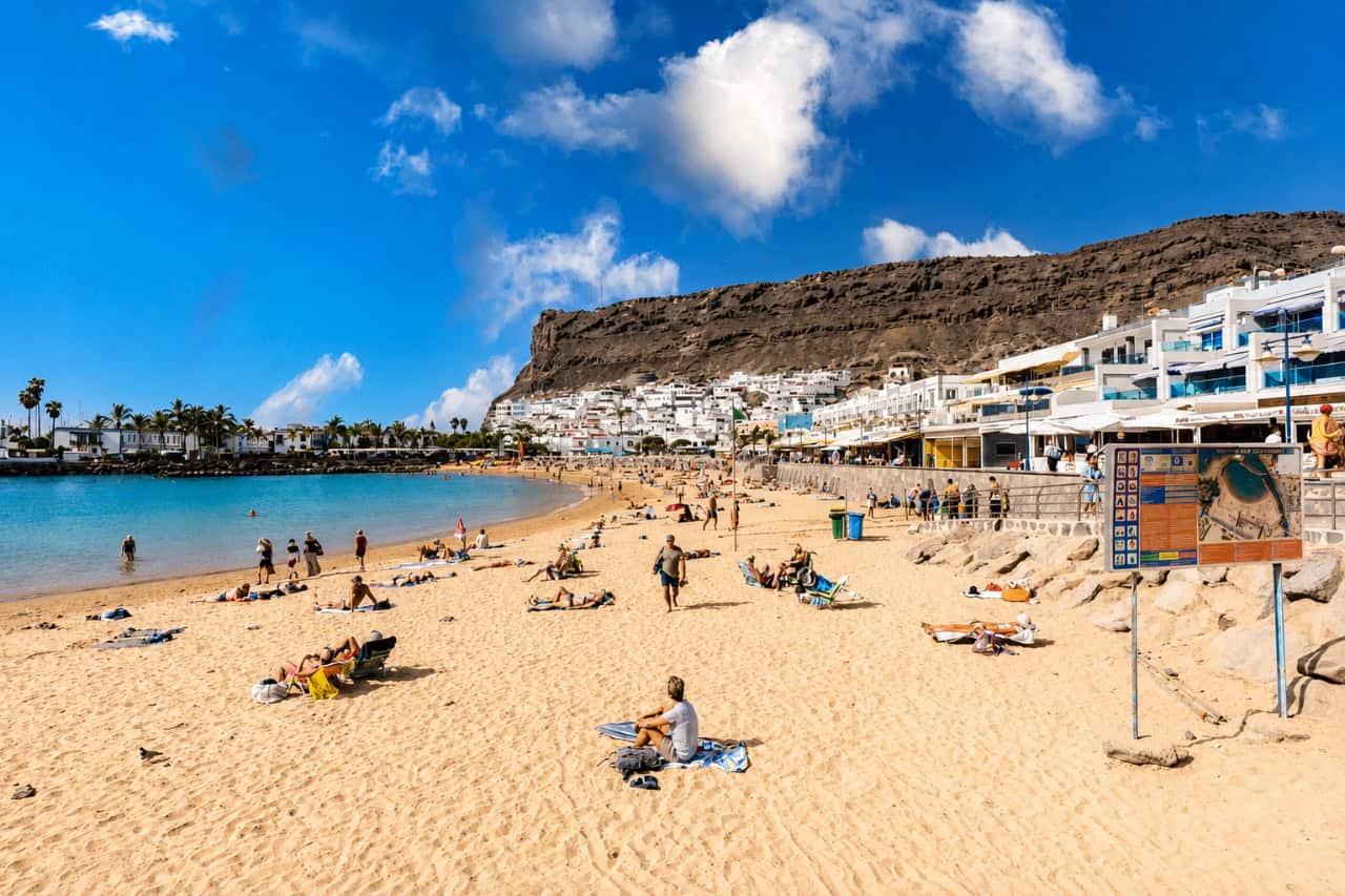 Sunny beach and waterfront in Puerto de Mogán, where visitors can begin their first scuba diving experience in Gran Canaria.