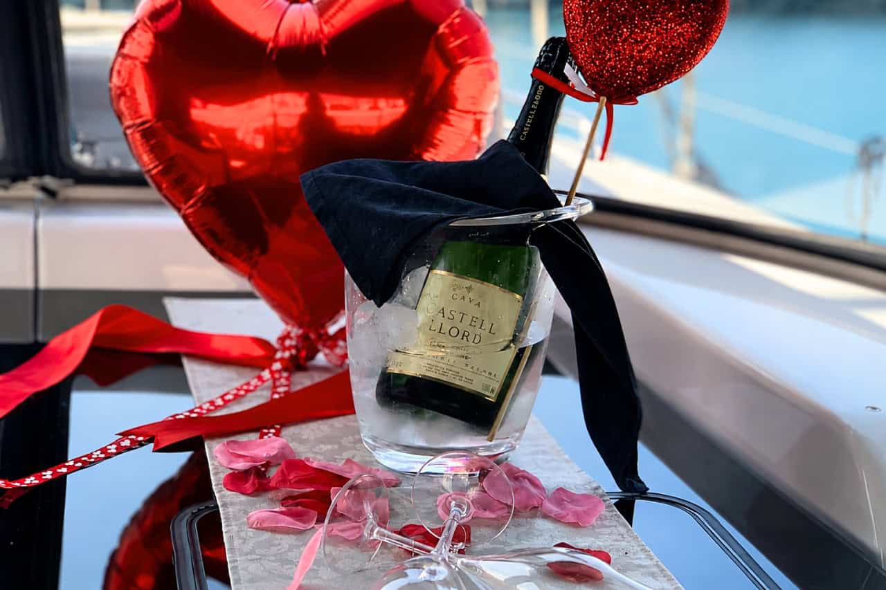 Romantische Atmosphäre an Bord der Segelyacht Blue Dream auf Gran Canaria mit gekühltem Cava, Rosenblüten, Champagnergläsern und Herzdekorationen.