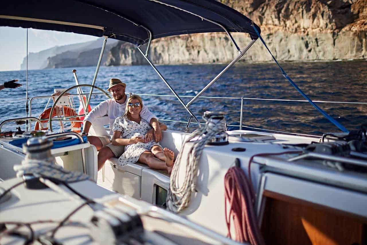 Egy pár pihen a Karolka vitorlás fedélzetén Gran Canaria partjai mentén történő magánvitorlás-bérlés során.