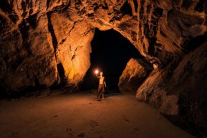 Guide tenant une torche à l'intérieur de la Cueva de los Verdes à Lanzarote lors d'une visite guidée de la Cueva de los Verdes à travers le tube de lave volcanique.