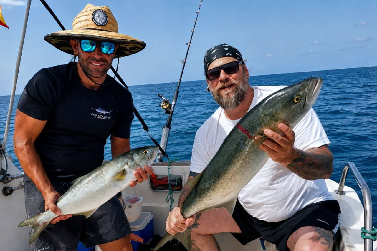 Two clients celebrating their catches on a private fishing charter in Fuerteventura