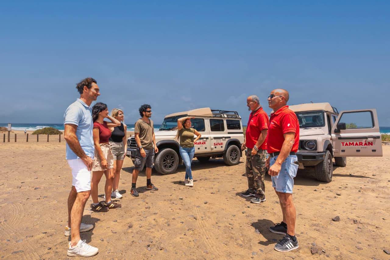 5 guests meeting their 2 guides beside Jeep Safari in 4x4 vehicles before the Fuerteventura off-road tour.