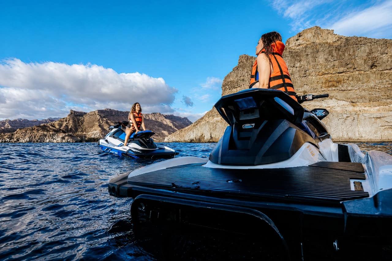 Dos mujeres montando en moto de agua por la costa rocosa de Gran Canaria durante un safari en moto de agua.