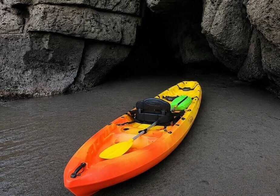 Colorful kayak resting beside a volcanic sea cave during a Gran Canaria kayaking tour.