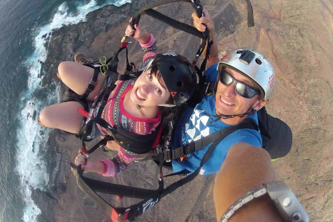 Tandem-Gleitschirmflug-Erlebnis auf Gran Canaria mit einem Fluglehrer über der felsigen Küste der Insel und dem Atlantischen Ozean.