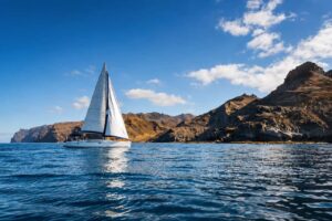Segelyacht auf dem Atlantischen Ozean auf einer Fahrt entlang der dramatischen Vulkanküste von Gran Canaria.