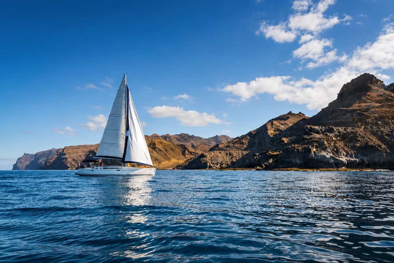 Voilier naviguant le long de la côte volcanique spectaculaire de la Grande Canarie sur l'océan Atlantique.