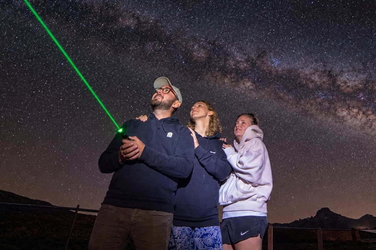 Guide using a green laser to point out stars in Teide
