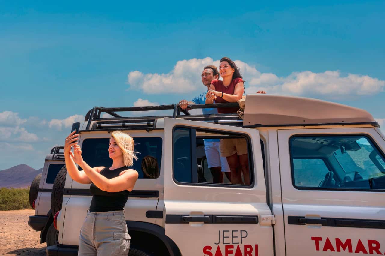 Travellers enjoying the views and taking photos from an open-top Jeep during a safari tour in Fuerteventura.