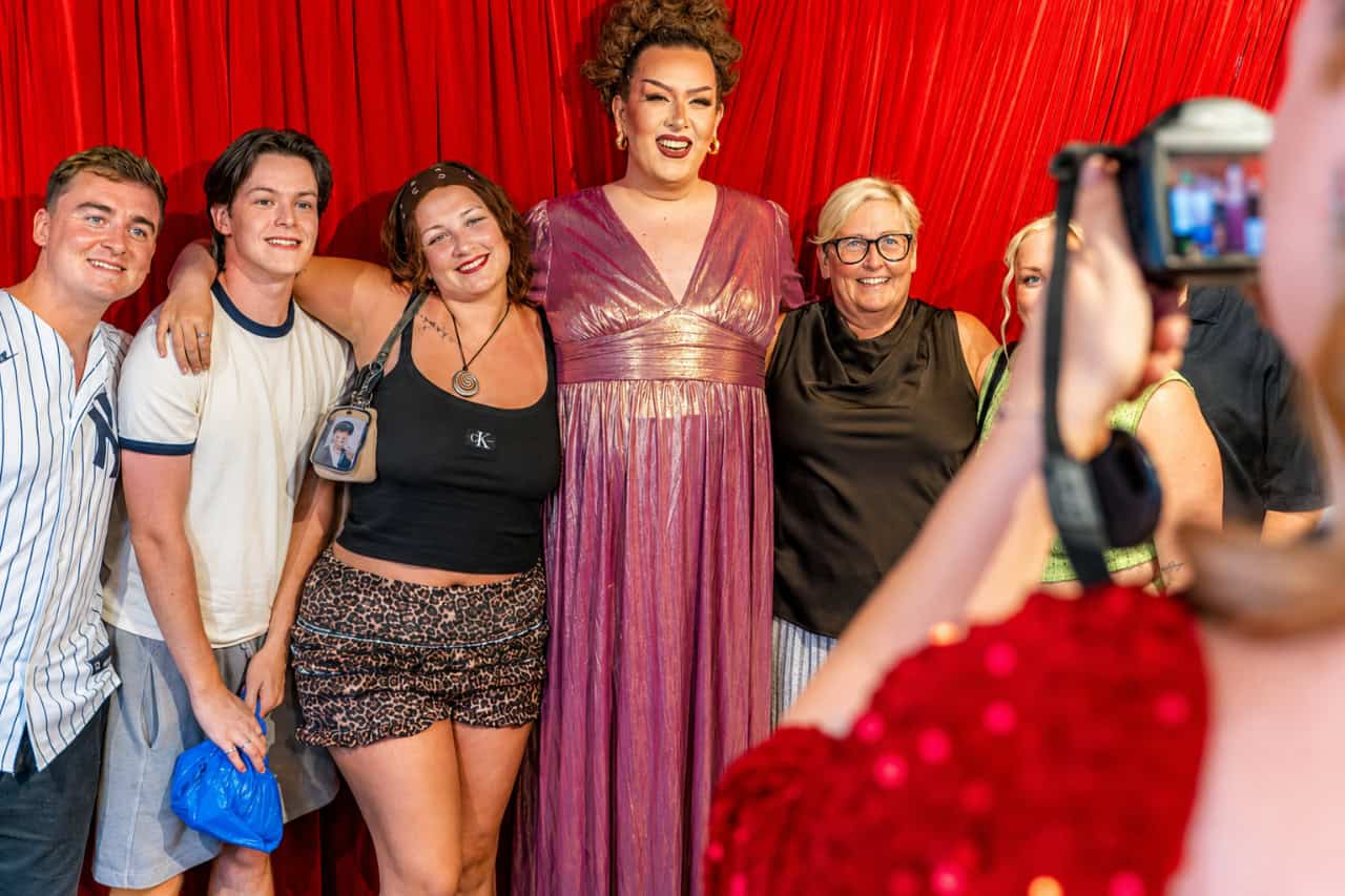 Guests posing for a photo with a drag performer during the Music Hall Tavern show in Lanzarote.