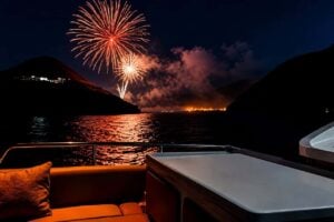 Red fireworks over the Lanzarote coast viewed from the deck of an evening boat cruise.
